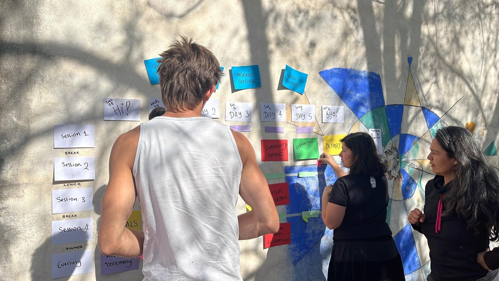 Les group leaders de Focus Pocus organizan el programa del intercambio en una pared, colocando tarjetas con las actividades y los momentos clave de cada día.